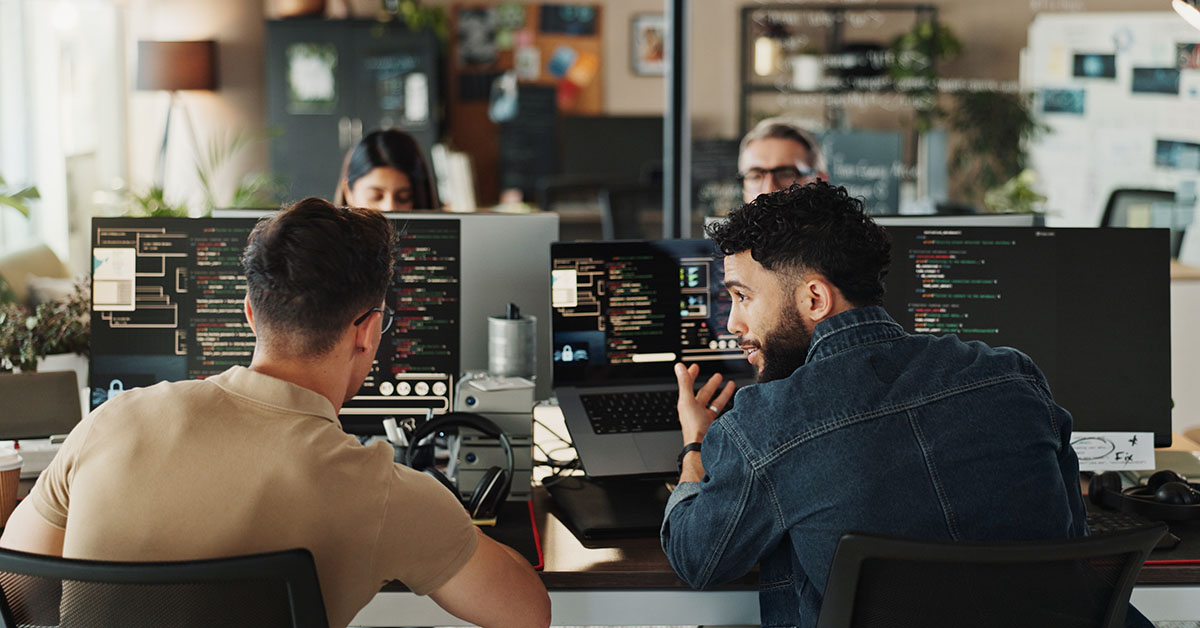 Man, developer and help with coding on computer screen in office for testing web application or troubleshooting. Programming, staff and employee with advice on developing software solution at startup Software developers at work